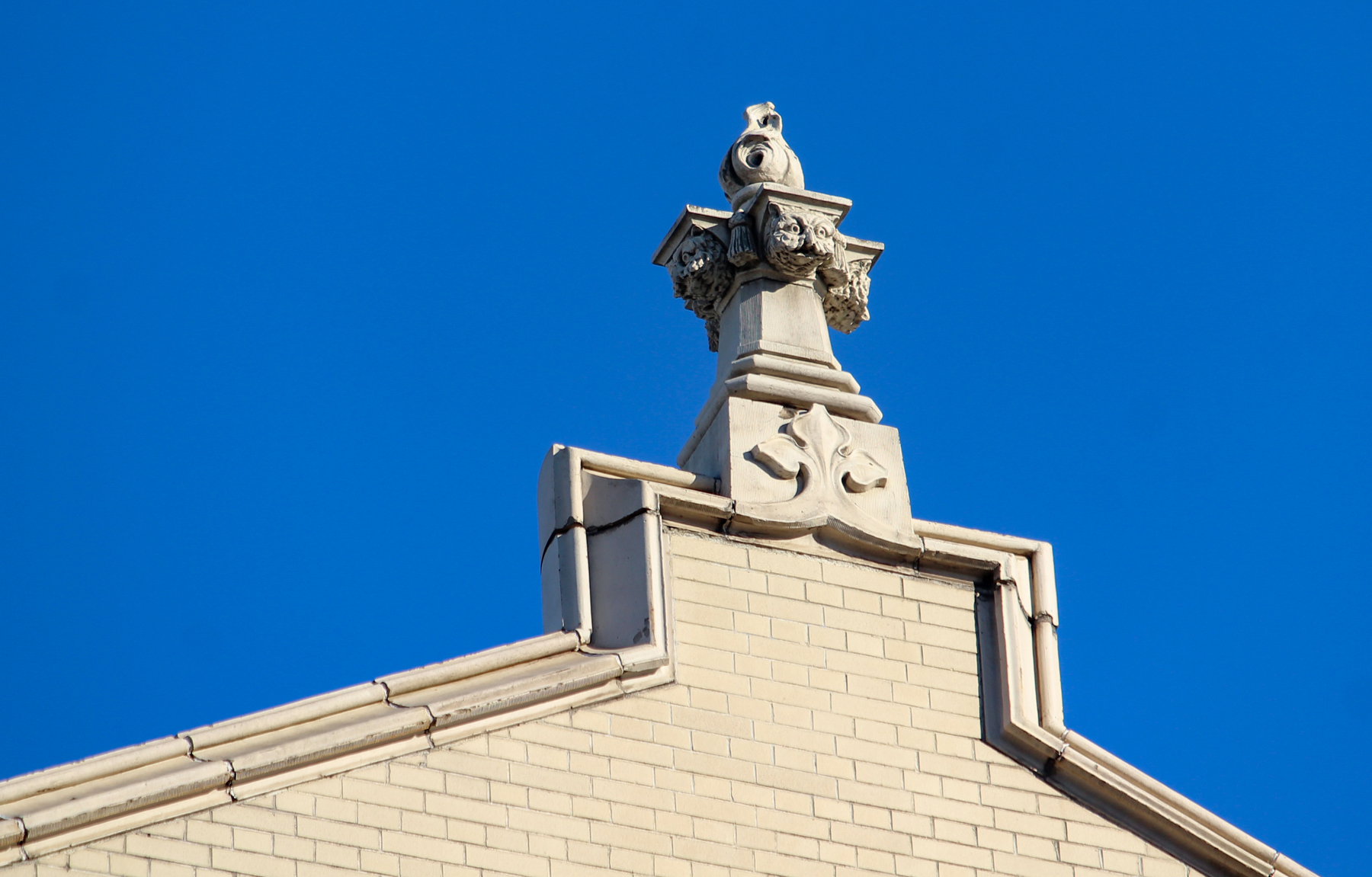 decorative detail at the top of the building includes faces