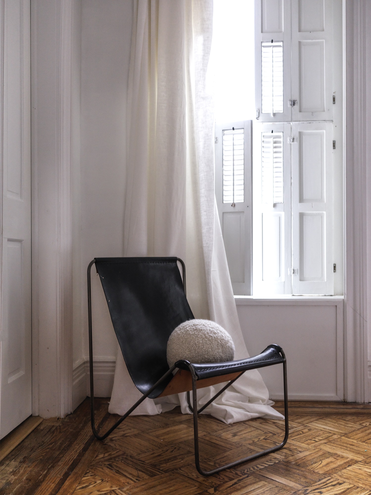 LEATHER SLING CHAIR BY WINDOW